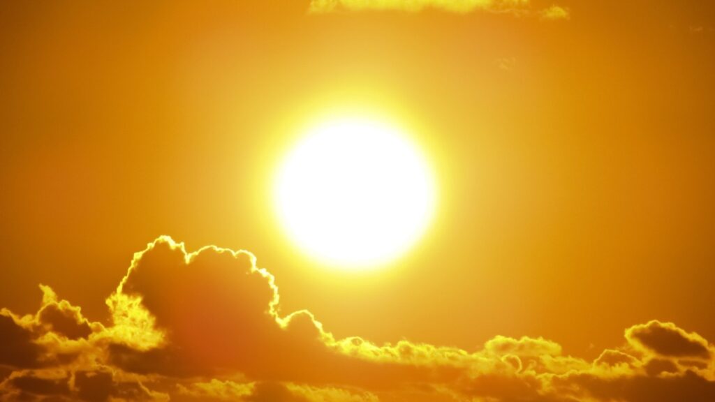 A blazing summer sun in an orange sky.