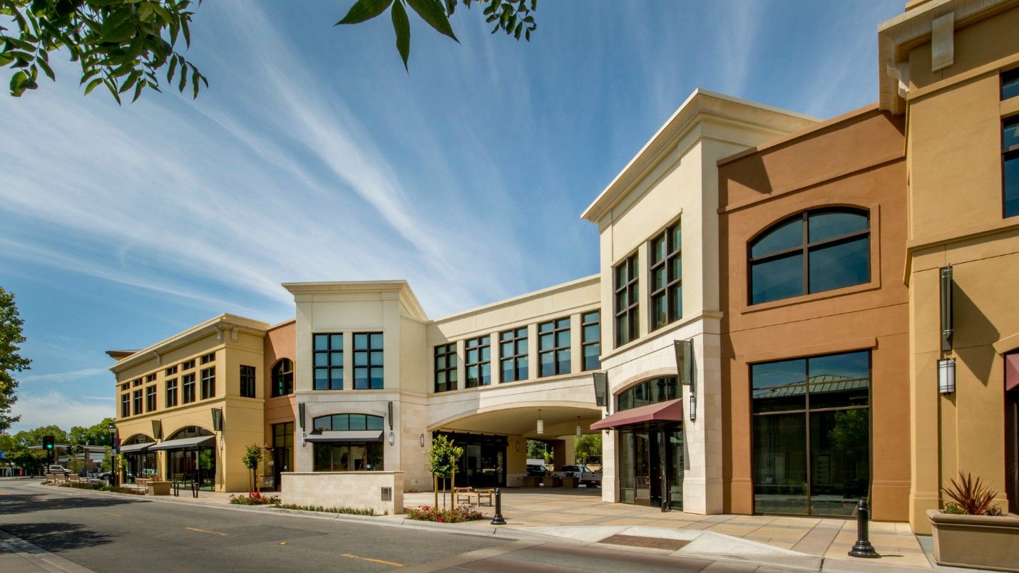 A street with many commercial buildings under a blue sky.