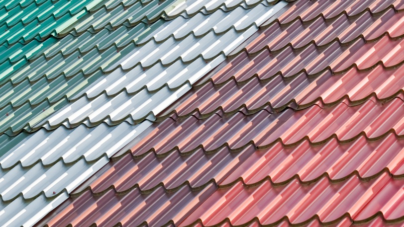 A series of colorful roofing tiles that range from light to dark shades of multiple colors.